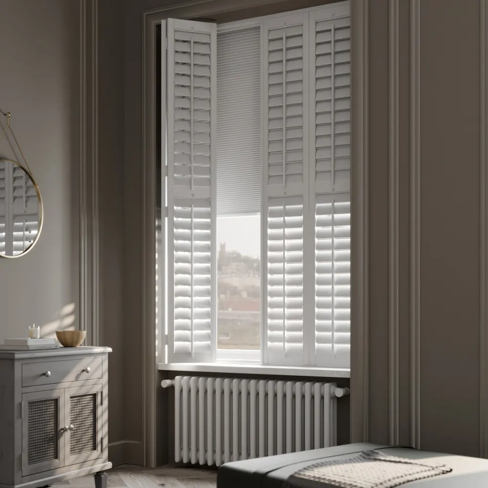 White plantation shutters folded back from a tall sash window, with the lower louvres open